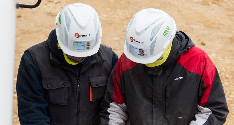 Two men in hard hats on a construction site. 